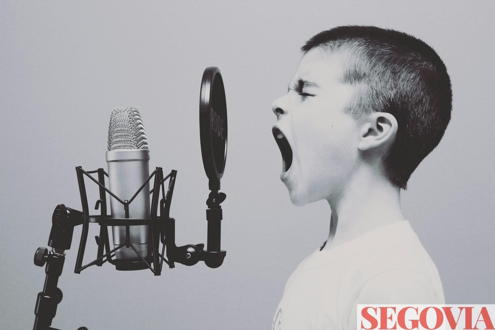 boy singing on microphone with pop filter