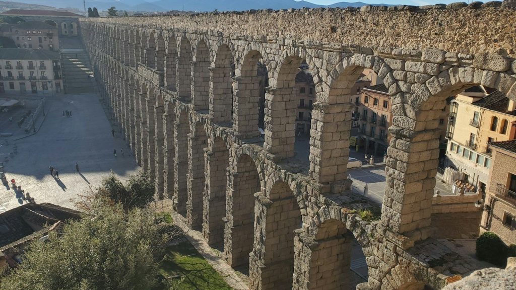 Gran edificio histórico de piedra sobre una colina, paisaje de Castilla